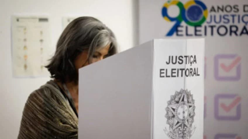 Eleitora na cabina da urna eletrônica exercendo o voto secreto