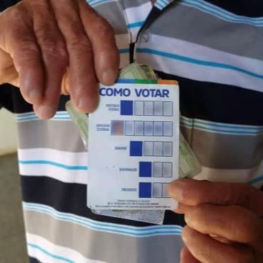 Colinha eleitoral em papel com os números dos candidatos